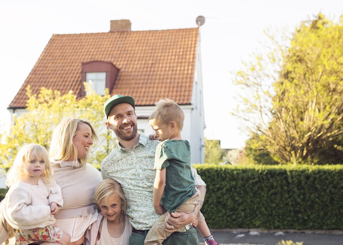 Happy family with children in front of their home